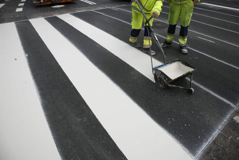 two workers painting the road